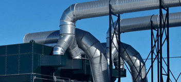 Large fabricated sheet metal tubing and ductwork against a blue sky