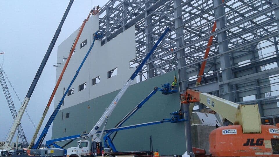 Cranes and lifts working a steel-frame industrial build at the New Gold site